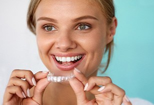 A woman holding a take-home teeth whitening tray