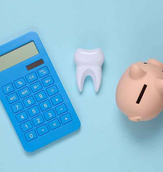 A piggy bank, calculator and tooth on a blue background.